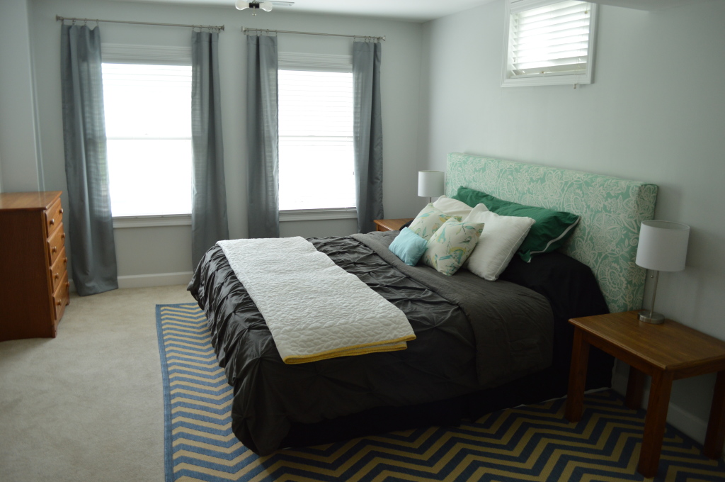 Guestroom bed with curtains and nightstands and chest