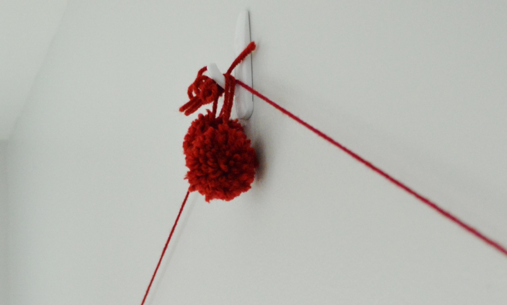 winter wall hanging with dowel rods and yarn pom poms